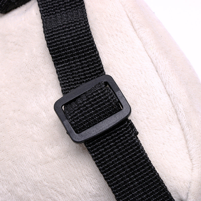 Black adjustable nylon bag strap with a rectangular buckle detail on a cream-colored bag.